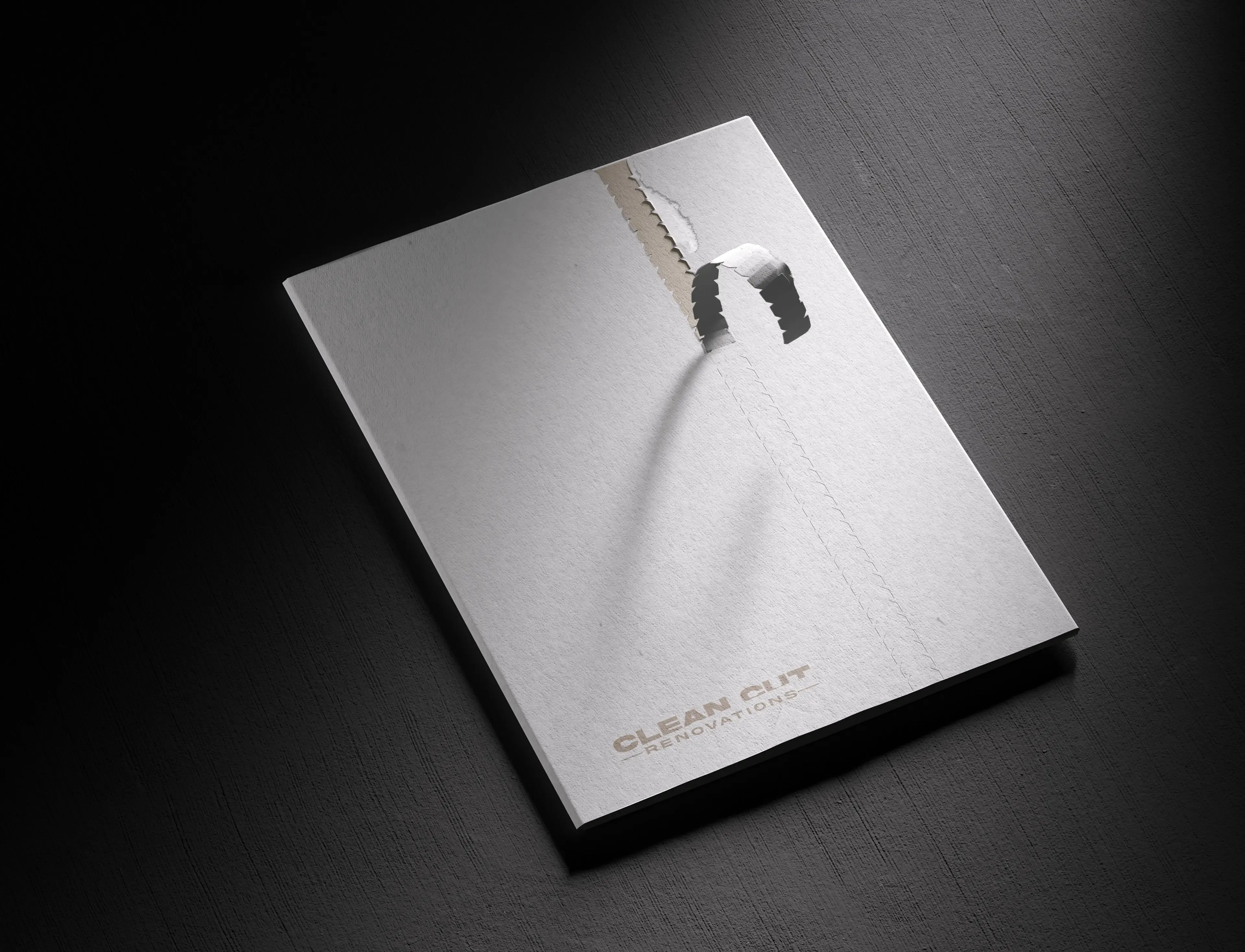 Brand collateral folder with a torn paper effect that reveals the Clean Cut Renovations brand identity underneath