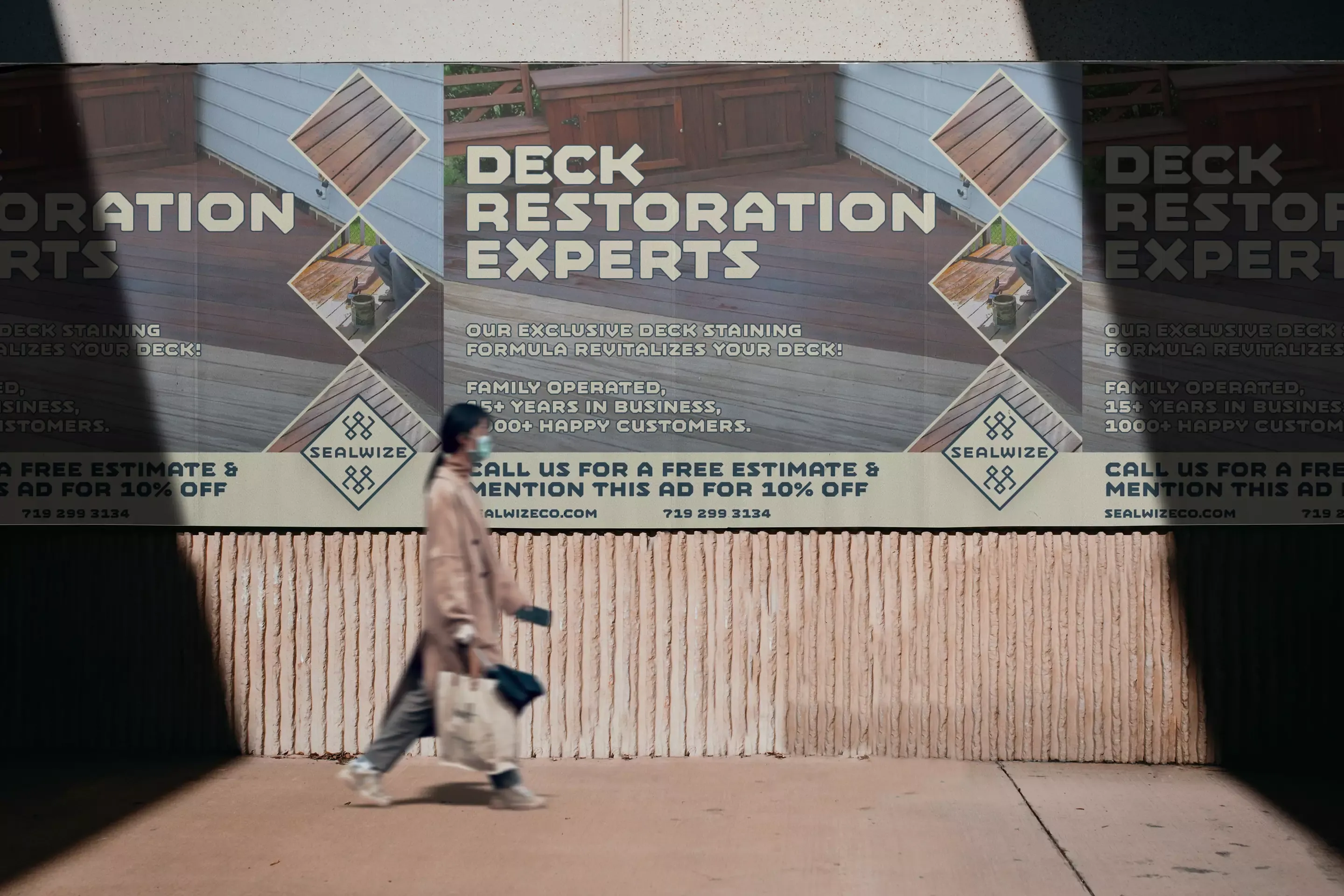 Billboard advertisement showing the old Sealwize brand identity with the metallic badge logo, promoting deck restoration services in Colorado Springs
